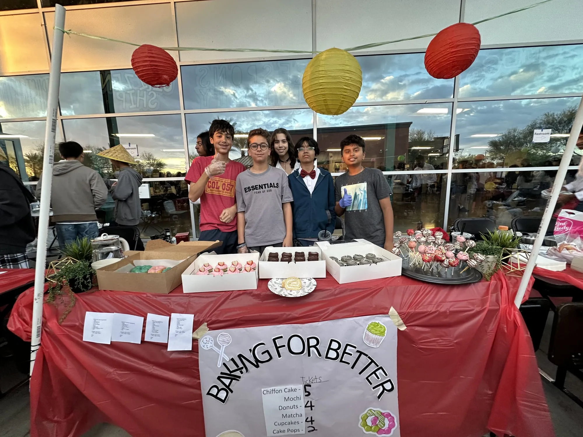 Students behind a bake sale table with a Baking for Better sign